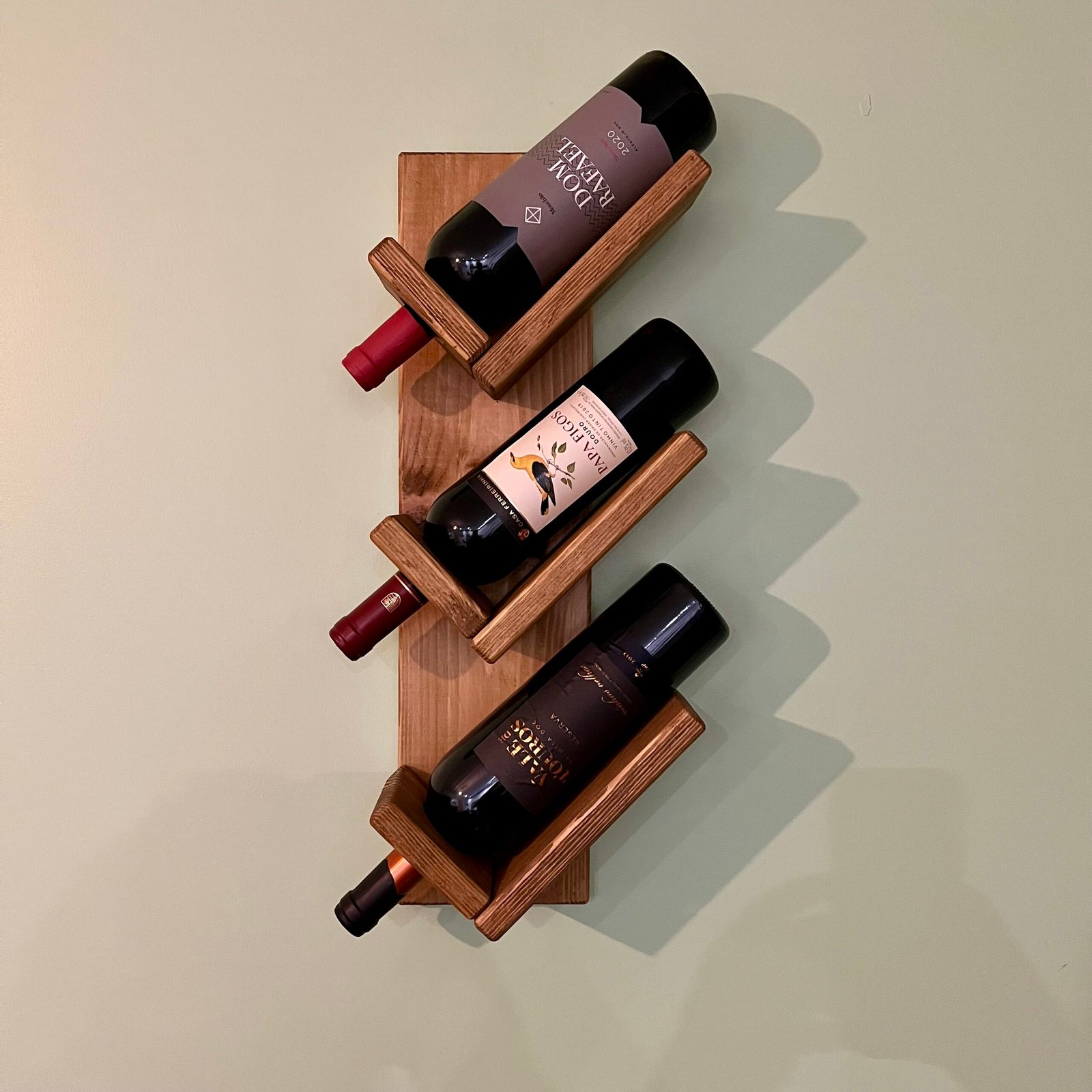 Handmade wooden wall wine rack mounted vertically with rustic finish